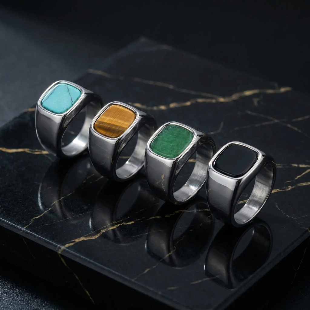 Four silver stone rings on black marble