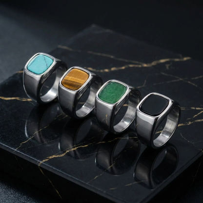Four silver stone rings on black marble